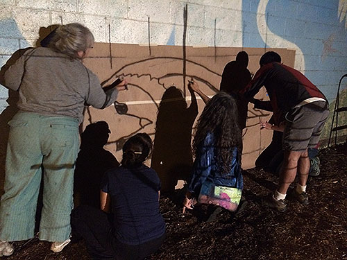 tracing over projected lines to create a large barn owl stencil for the future M and Duke street mural