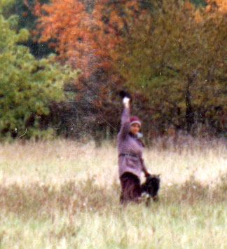 Photo of handler holding up an article found and retrieved by teh tracking dog on an FH track.